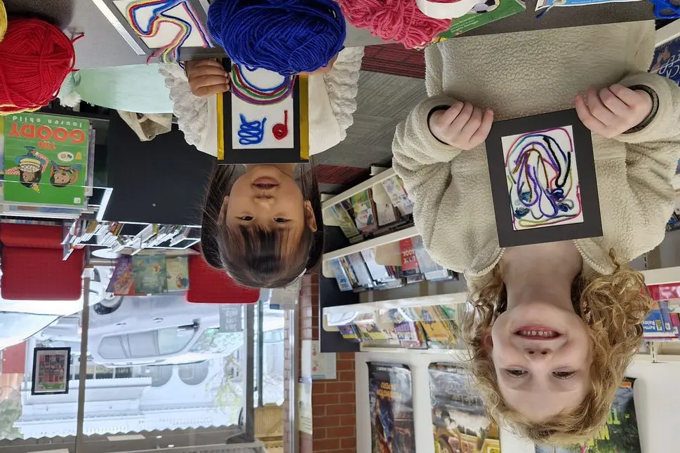 LIBRARY FUN: Joreyn Rofe (6 years old) of Euroa and Danika Somlong (4) of Violet Town were busy creating their own Textural Wool Paintings at the Euroa library last Thursday when the Gazette dropped by. PHOTO: Pam Zierk-Mahoney\\n