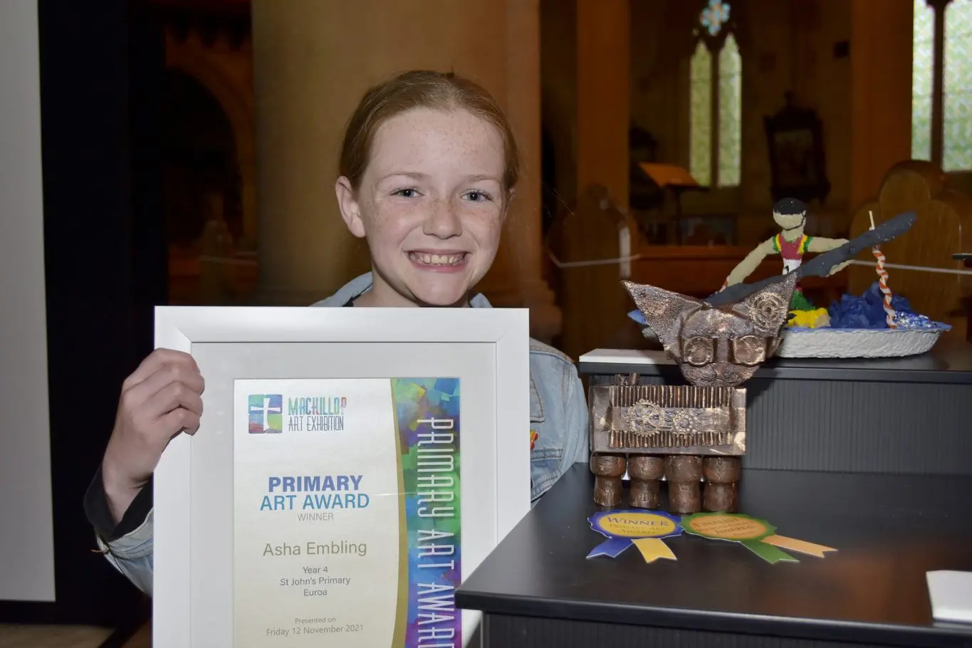 PRIMARY ART AWARD: Asha Embling proudly shows off her art work and certificate that she received as part of the Mackillop Art Exhibition.